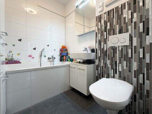 Das Badezimmer 2 mit einer Dusch-Badewanne, die sich gut für Kinder oder ein entspanntes Abendbad eignet