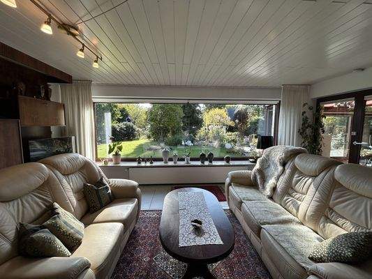 Wohnzimmer mit Panoramablick in den Garten