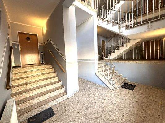 Gepflegter Hausflur. Die Treppe links führt zur Wohnung.