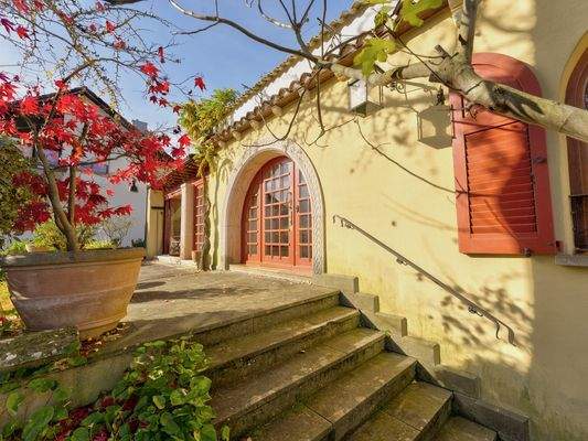 großzügige Eingangstür mit eingefasstem Rundbogen aus Sandstein mit Intarsienarbeiten