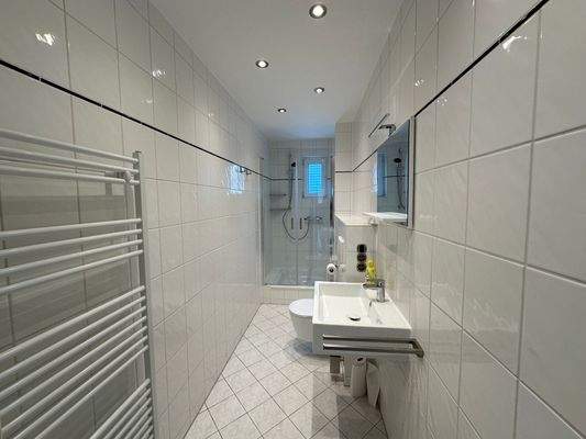 Badezimmer mit Dusche und Fenster