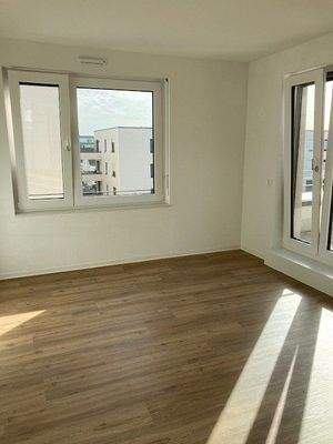 Schlafzimmer mit Zugang zur Loggia und einem weiteren Fenster