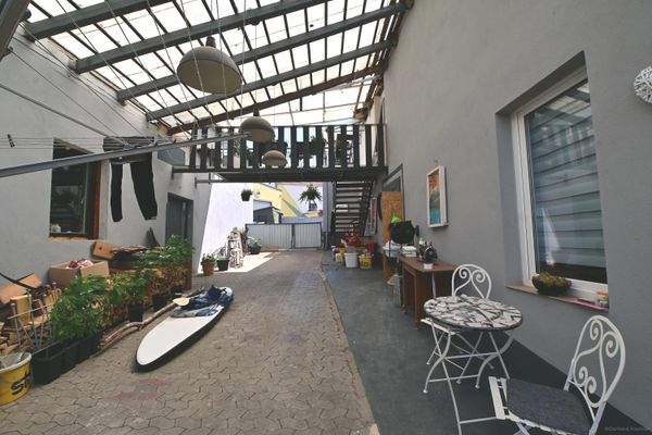 Hof mit Überdachung zwischen Haus und Nebengebäude