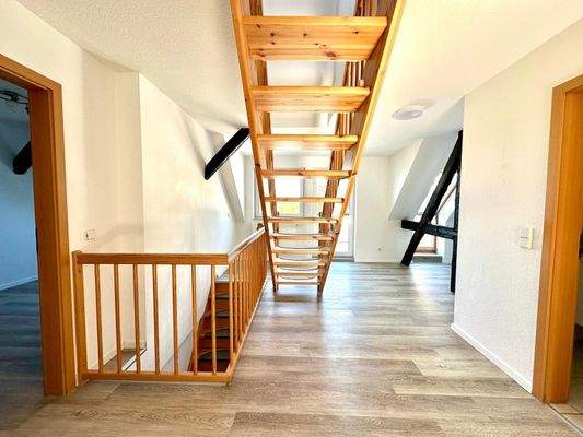 Offen gestalteter Wohnraum mit Treppe ins Obergeschoss