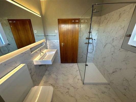 Luxuriöses Designbad mit Marmor-Ambiente und moderner Dusche