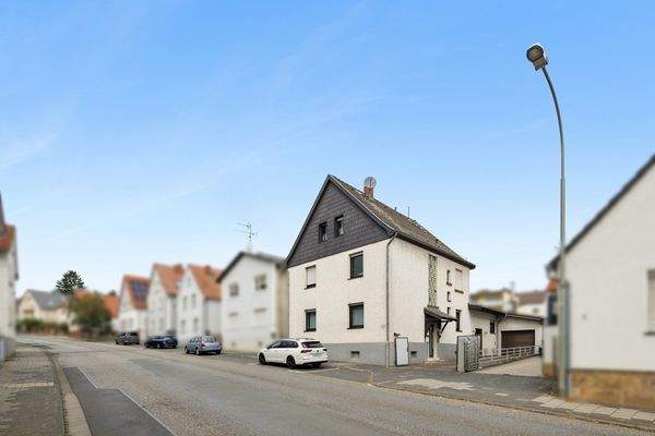 Vorderhaus mit Satteldach und Hofzufahrt mit Garage und Stellplatz