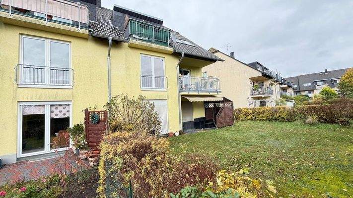 Hausansicht mit Mietergärten und Balkonen