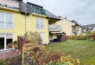 Hausansicht mit Mietergärten und Balkonen