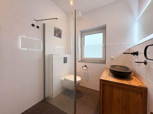 Tageslichtbad mit großer Dusche.