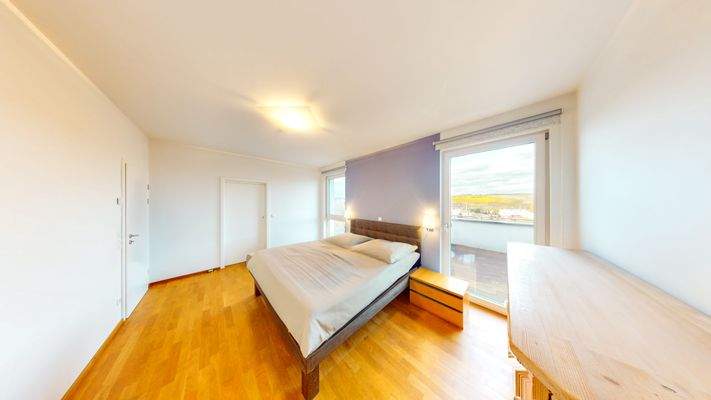 Schlafzimmer mit Zugang zum Ankleidezimmer und Badezimmer