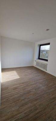 Schlafzimmer mit hellem Vinylboden und weißen Wänden, Fenster (2).jpg