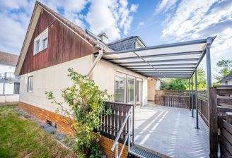 Ein Zuhause mit viel Raum und einer Terrasse, die das Leben nach draußen verlängert.