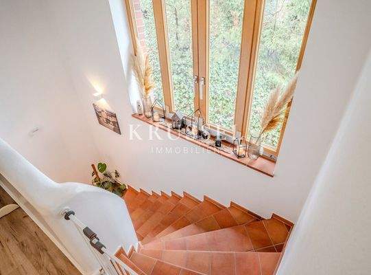 Charmantes Treppenhaus mit mediterranen Fliesenstufen und großzügigem Fenster für viel Tageslicht