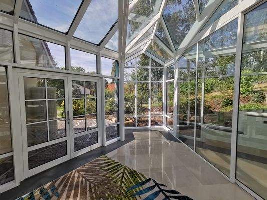 Eingangshalle des Spabereichs mit großem Glasdach und Blick ins Grüne