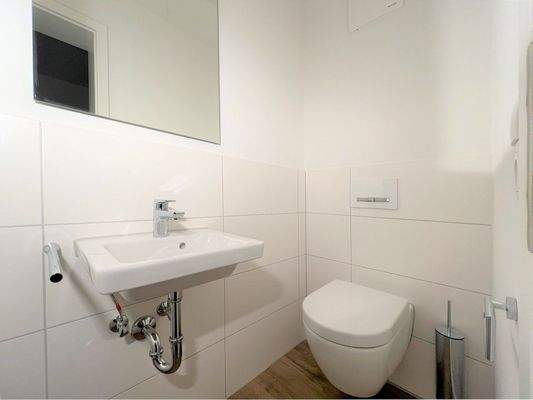 Modernes Gäste-WC mit designer Wandtoilette und zeitlosem Waschbecken