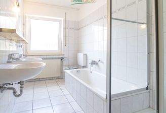 Badezimmer mit Badewanne und Duschkabine