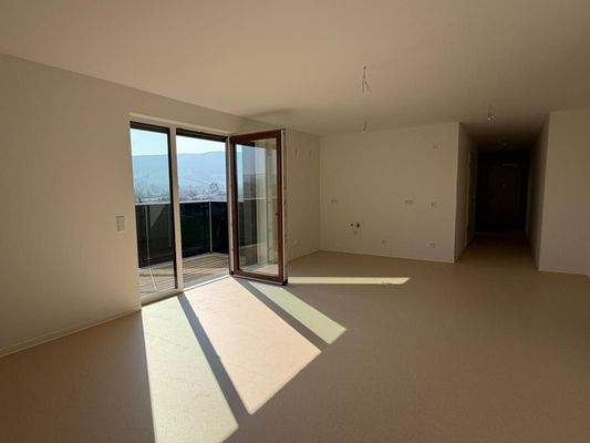 Offener Wohn-Essbereich mit Ausgang zum Balkon