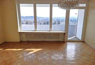 Wohnzimmer mit großer Fensterfront und einem Panoramaausblick auf Kaufbeuren 