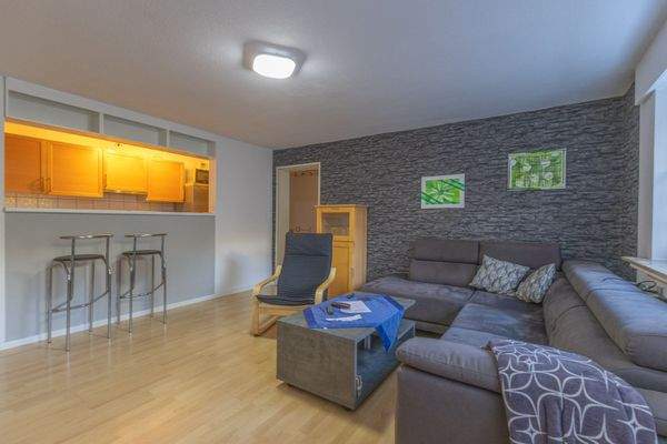 Wohnzimmer mit halb offener Küche und Tresen