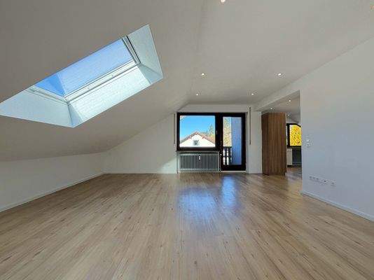 Wohnzimmer: Weiter Wohnbereich unter Dachschräge mit Balkonzugang und viel Raum