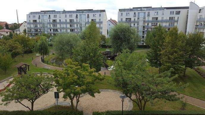 parkähnlicher Innenhof mit Teich und Insel