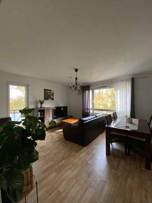 Wohnzimmer mit weißen Wänden, PVC Boden in Holzoptik und Fenster und Mietereinrichtung.jpg