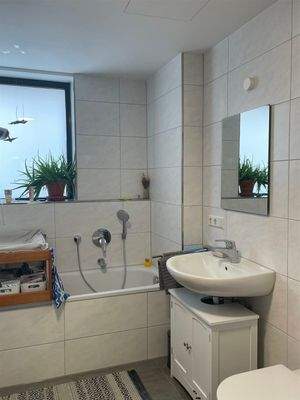 und in ein Bad mit Dusche, Badewanne und WC ...