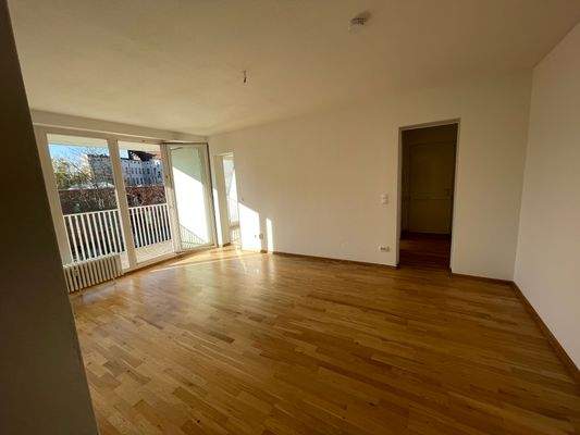 Wohnzimmer mit Balkon und Durchgang zur Küche