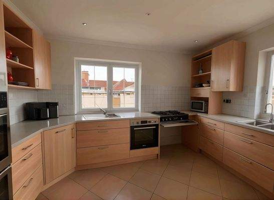 Moderne Einbauküche mit Gasherd und Panoramafenstern - Lichtdurchfluteter Kochbereich mit optimaler Arbeitsplattenausstattung