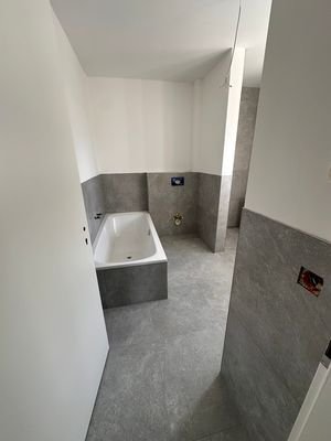 Badezimmer mit Badewanne, Dusche und Fenster
