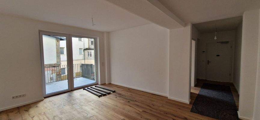 Wohnzimmer mit Parkett und großem Balkon