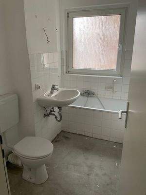 Tageslichtbad mit Badewanne und weißem Fliesenspiegel