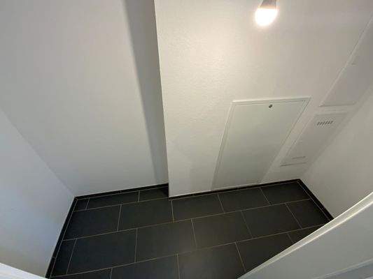 Abstellraum mit weißen Wänden und Waschmaschinenanschluss