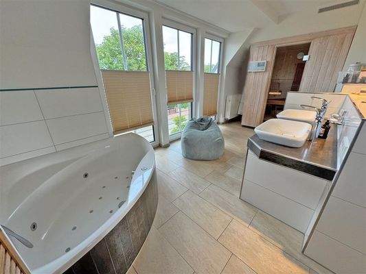 Badezimmer mit Eckbadewanne und Sauna