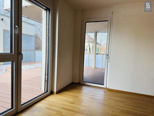 Wohnzimmer mit zwei Fenstertüren zur Terrasse