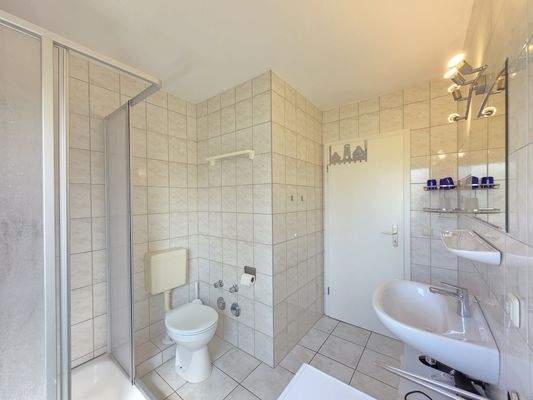 Badezimmer mit Dusche und Waschmaschinenanschluss