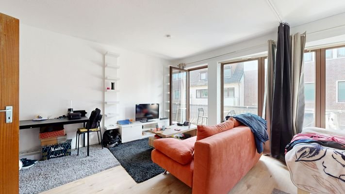 Wohn- und Esszimmer mit Schlafbereich und Küchenzeile.