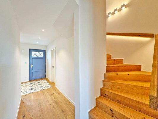 Echtholztreppe ins Obergeschoss mit aufwendigen Lichtelementen