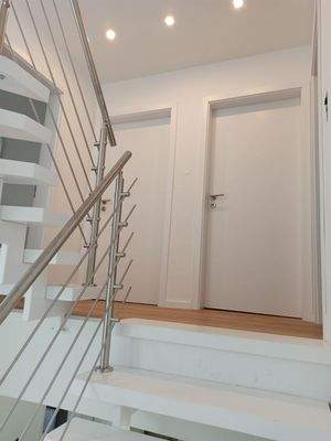 Holztreppe mit modernen Edelstahlgeländer