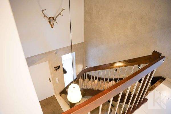 Eine elegante Treppe mit Luftraum verbindet die Etagen