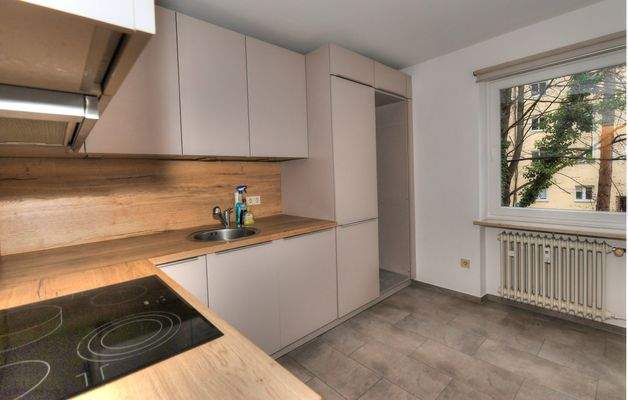 Küche mit neuerer Einbauküche und Platz für Waschmaschine und Trockner