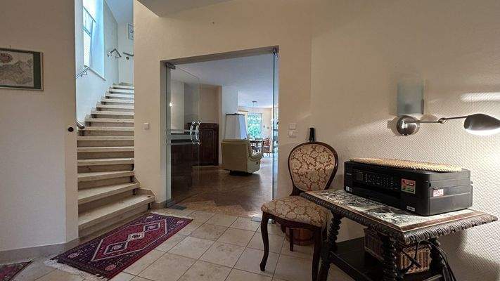 Eingangsbereich mit Geschosstreppe und Blick ins Wohnzimmer