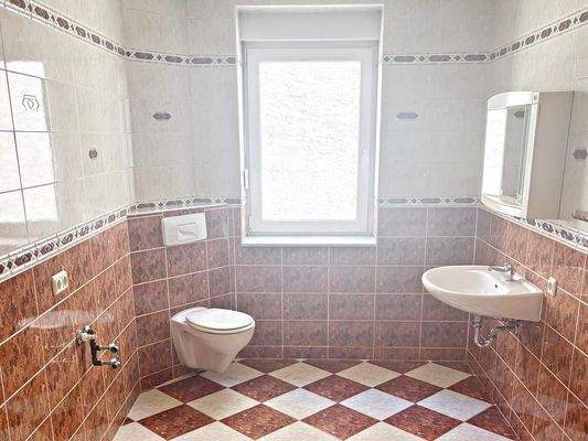 Toilettenbadezimmer mit Fenster und Waschmaschienenanschluss