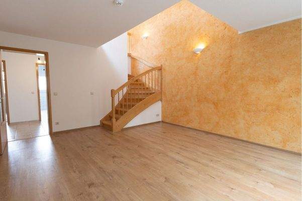 Wohnzimmer mit Aufgang zur oberen Ebene