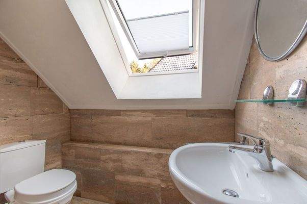 Modernes Bad mit Natursteinoptik und großzügiger Fensterfläche