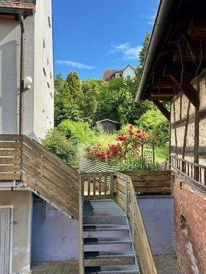 Blick zwischen Nebengebäude und Haus