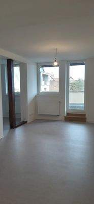 Wohnzimmer mit angrenzender Küche und Balkon