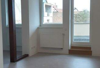 Wohnzimmer mit angrenzender Küche und Balkon