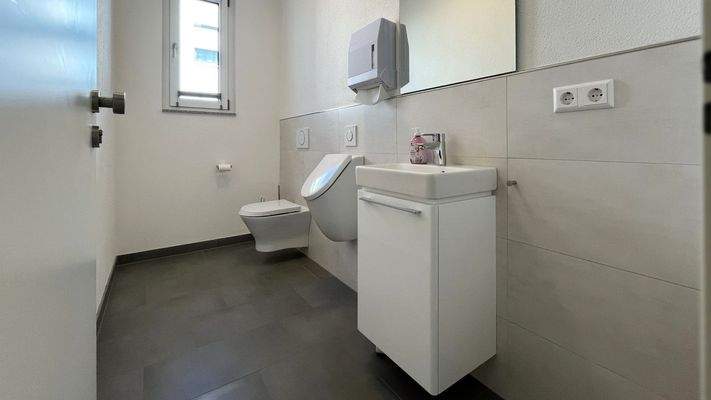 Modern ausgestattetes Kunden- oder Mitarbeiter-WC im Erdgeschoss