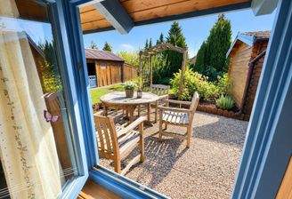 Sonniger Gartenblick durchs blaue Fenster